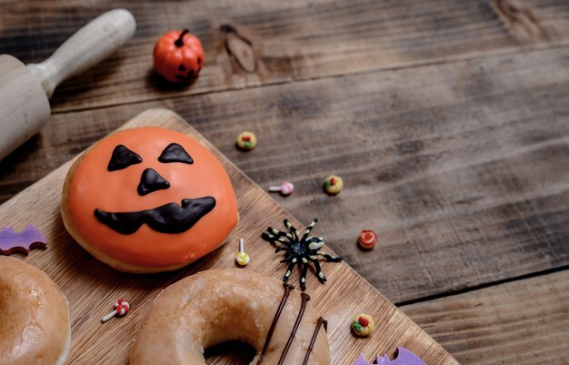 Cooking delicious homemade cake and decorate donut for Halloween festive. Sweet dessert and decoration for party at home.