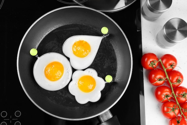 Cooking of delicious sunny side up eggs in molds, top view
