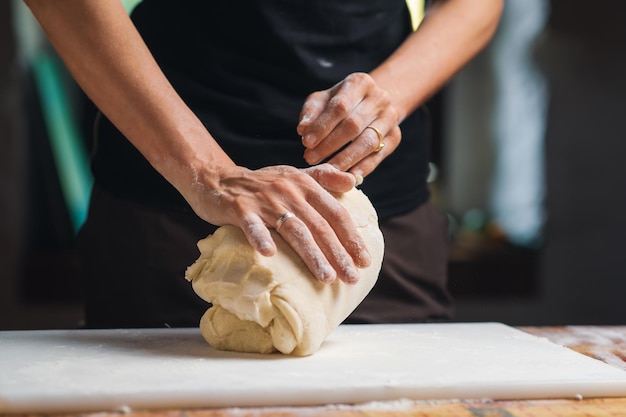 Cooking dough Women's hands kneading dough in kitchen Unrecognizable woman is engaged in cooking