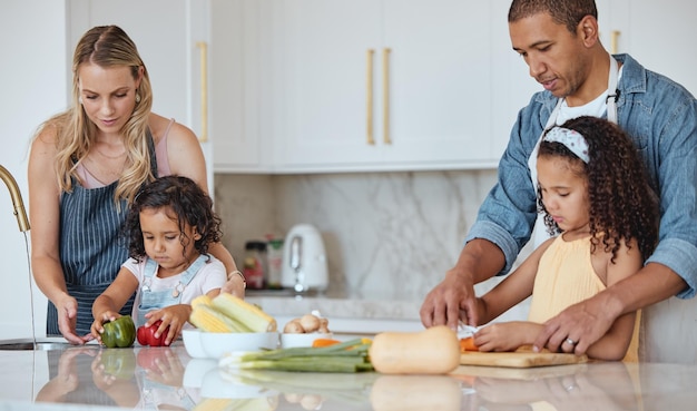 Photo cooking family and kitchen learning of a girl with mother and dad with love and parent support interracial teaching and vegetables in a house with children and parents making health and diet food