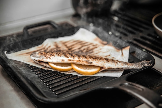 Cooking fish on a grill with lemon