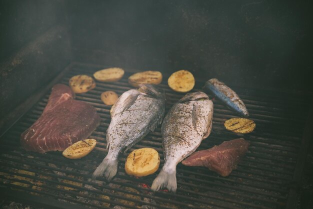Cooking fish and potatoes on grill