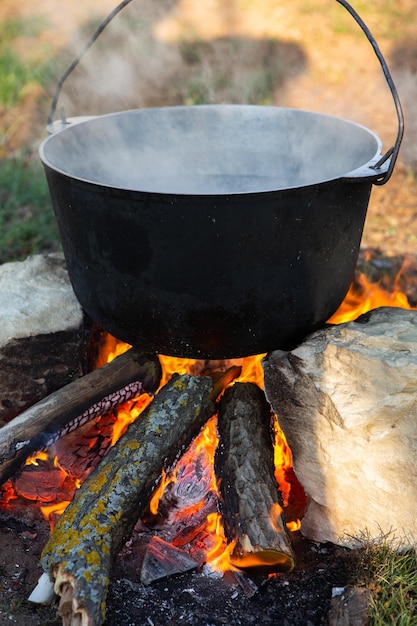 Cooking fish soup over an open fire in a kettle