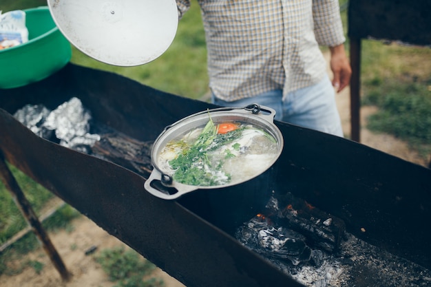 Cooking food at a campsite or recreation center, fish soup cooked on the grill