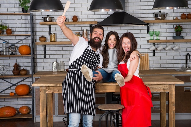 Cooking food concept Prepare delicious meal Breakfast time Family having fun cooking together Teach kid cooking food Cooking together Family mom dad and daughter wear aprons stand in kitchen