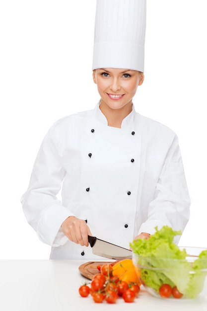 cooking and food concept - smiling female chef chopping vegetables