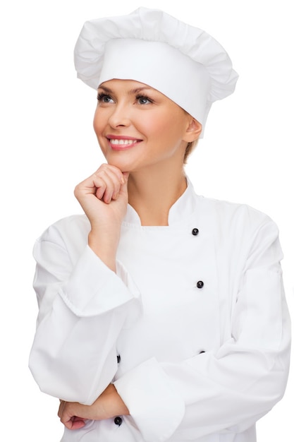 концепция кулинарии и еды - мечтающая улыбающаяся женщина-повар, повар или пекарь