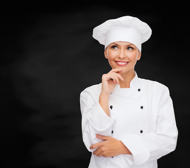 요리 및 음식 개념 - 웃는 여성 요리사, 요리사 또는 제빵사 꿈