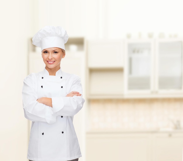 cooking and food concept - smiling female chef, cook or baker with crossed arms