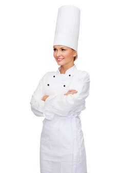 Concetto di cucina e cibo - chef femminile sorridente con le braccia incrociate