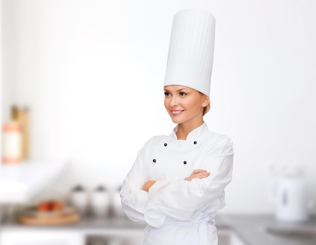 концепция кулинарии и еды - улыбающаяся женщина-повар со скрещенными руками