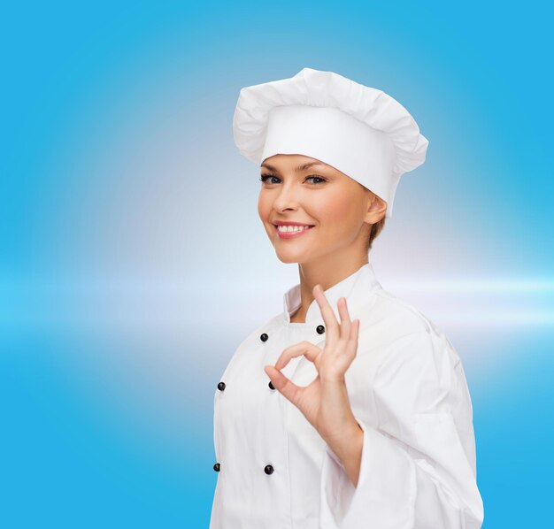 cooking, gesture and food concept - smiling female chef showing ok hand sign