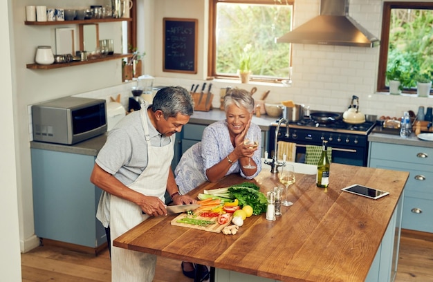 Фото Кулинарное счастье и пожилая пара с вином на кухонном столе