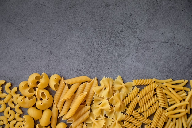 Cucinare il concetto di cibo sano diversi tipi di pasta su uno sfondo scuro