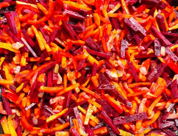 Photo cooking healthy food from vegetables chopped carrots with beetroot in a frying pan