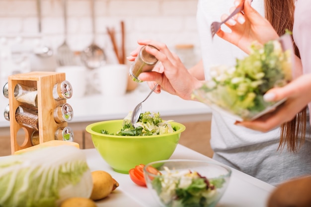 Cooking hobby. Organic foods. Healthy female lifestyle. Women making green salad.