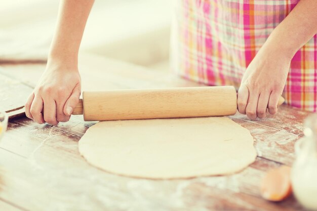 Cucina e concetto di casa - primo piano della donna che lavora con il mattarello