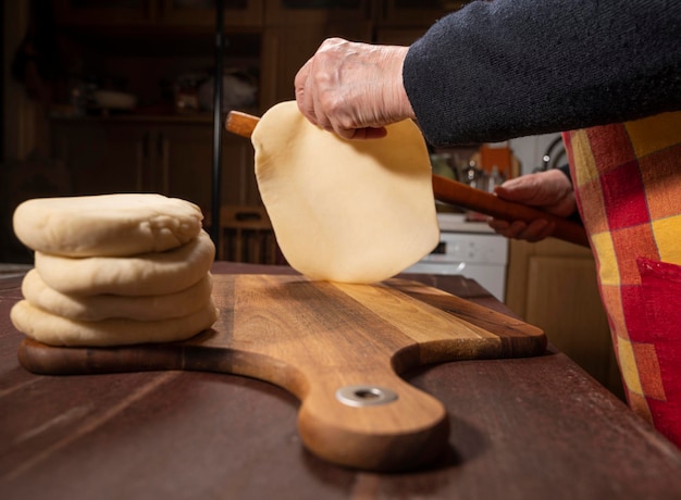 Cooking and home concept. Senior woman preparing tasty pies in the kitchen at home