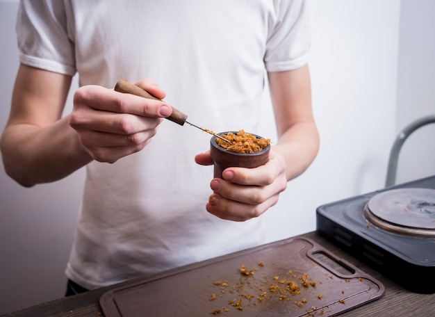 Cucinare il narghilè nel bar. tagliare il tabacco in una ciotola. ristorante