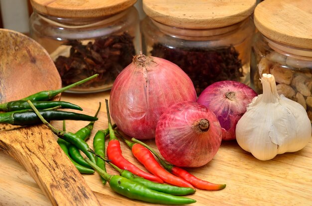 Ingredienti da cucina. spezie ed erbe aromatiche con cipolla e aglio su tavola di legno