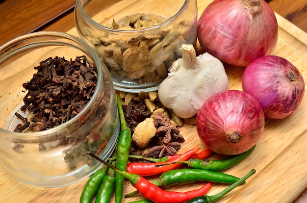 Ingredienti da cucina. spezie ed erbe aromatiche con cipolla e aglio su tavola di legno