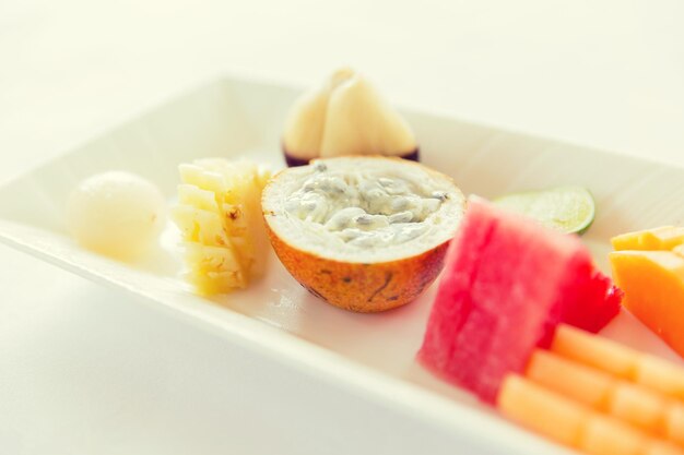 cooking, kitchen and food concept - plate of fresh juicy fruit dessert at restaurant