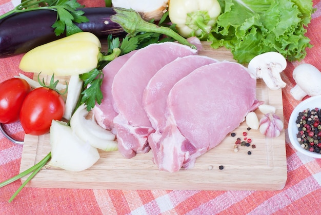 Cooking meat Pork with vegetables on wooden board