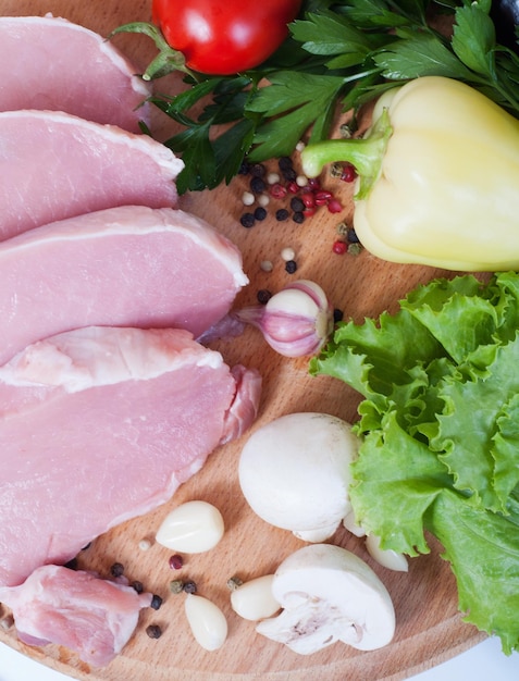 Cooking meat Pork with vegetables on wooden board