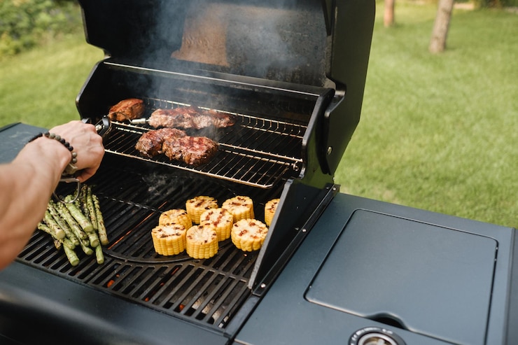 Photo cooking meat and vegetables on an outdoor grill