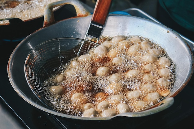 Cooking meatballs in the boiling oil in frying pan