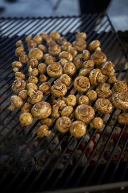 Cooking mushrooms on the coals on the grill Street food Champignons