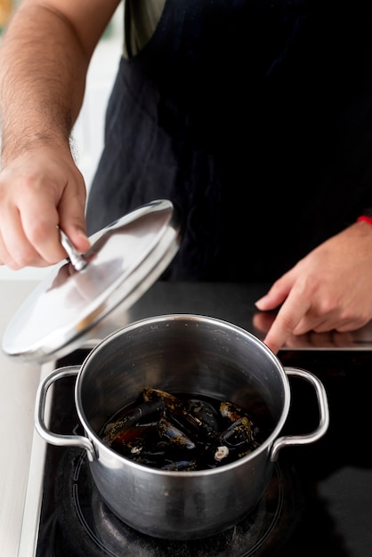 Cooking mussels and seafood in a cooking pot at home