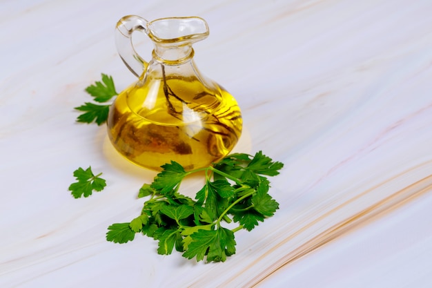 Cooking olive oil in glass bottle with parsley.