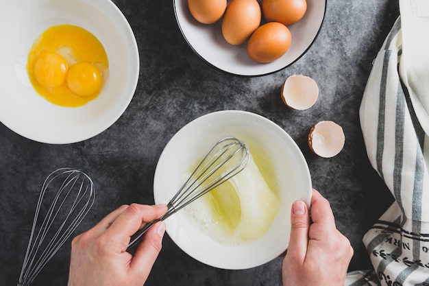 요리 omlette. 여자의 손에 신선한 달걀을 깨는 omlette 요리. 음식 평평하다.