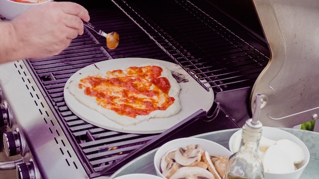 Cooking pizza on outdoor gas grill.