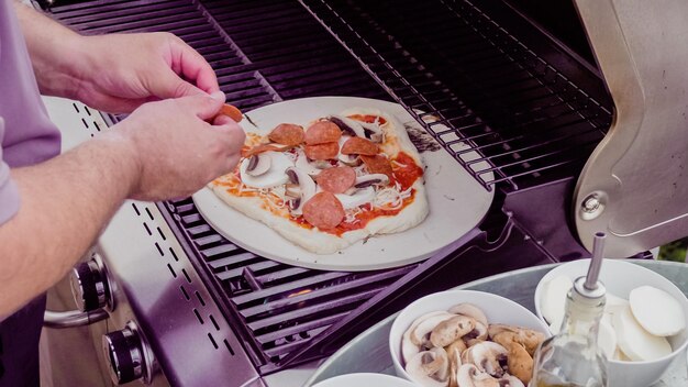 Cooking pizza on outdoor gas grill.