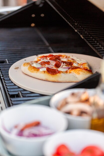 Cooking pizza on outdoor gas grill.