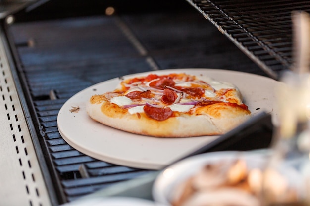 Cooking pizza on outdoor gas grill.