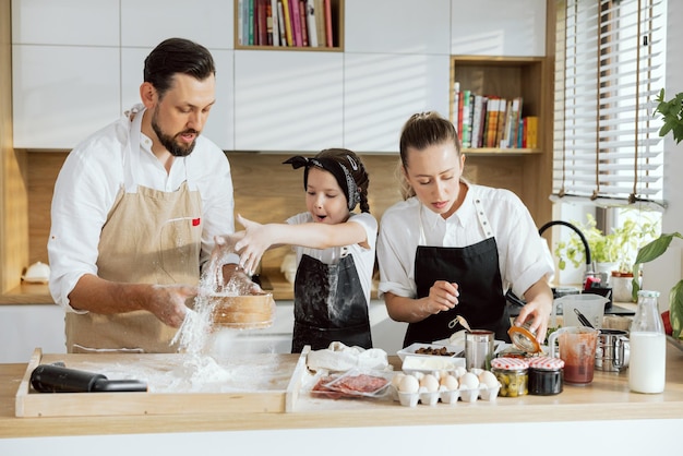 Cooking process family standing in modern kitchen father with adorable daughter