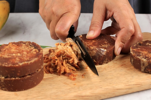 Cooking Process, Slicing Palm Sugar Block, Process Making Kolak, Traditional Indonesian Sweet Soup Made from Banana, Sweet Potato, Coconut Milk. Popular as Ramadan Breakfasting Menu