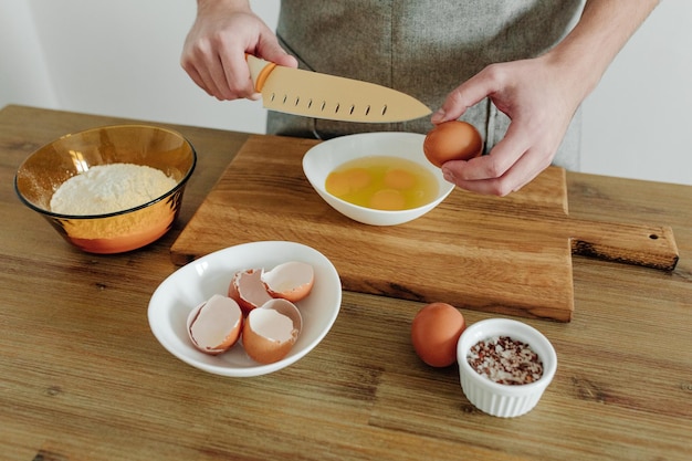 Cooking in progress Eggs flour salt on the table cutting board and knife Dough Ingredients