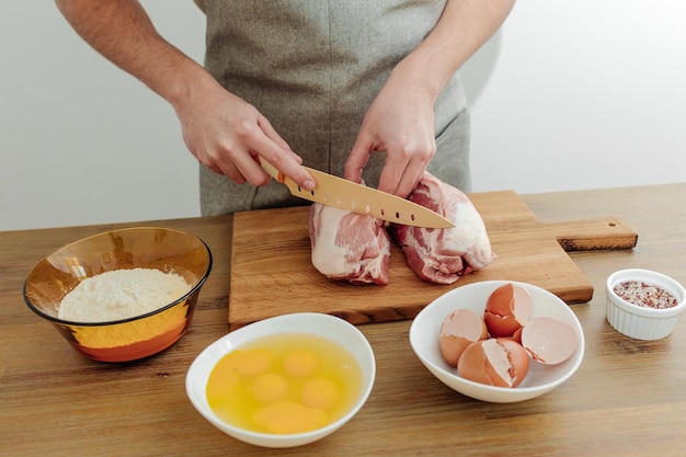 Cooking in progress Meateggs flour salt on the table cutting board and knife