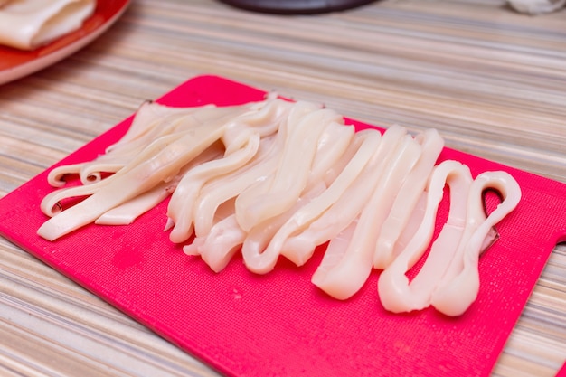 Cooking raw squid rings at home close up