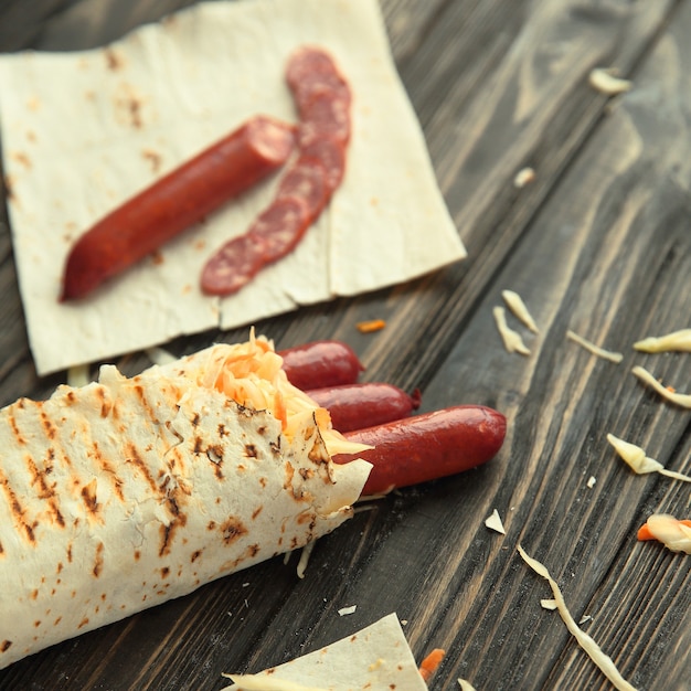 Cooking Shawarma with sausage. vertical photo with copy space.