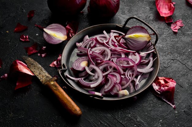 Cooking Sliced onion in a metal bowl Rustic style On a black stone background