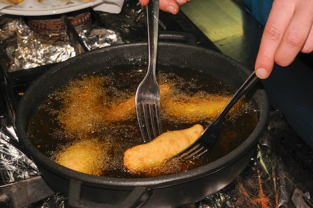 Cuocere delle empanadas di carne in olio d'oliva