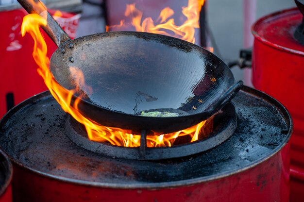 熱いフライパンで屋台の食べ物を調理する