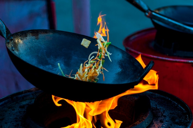 Cooking street food on a hot frying pan