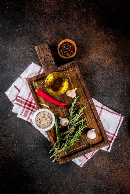 Cooking surface, herbs, salt, spices, olive oil on cutting board