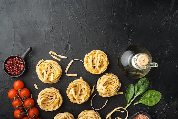 Cottura di tagliatelle e set di ingredienti, su sfondo di pietra nera, vista dall'alto piatta, con spazio di copia per il testo